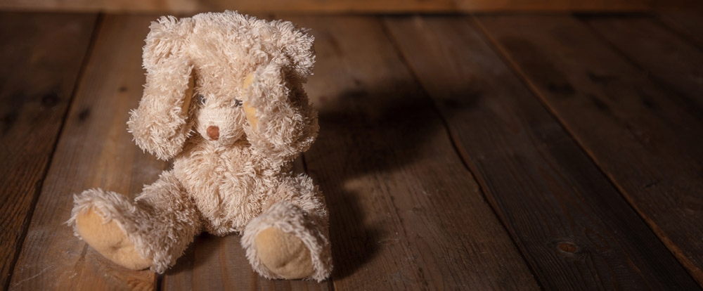 photo child abuse concept teddy bear covering eyes dark empty background